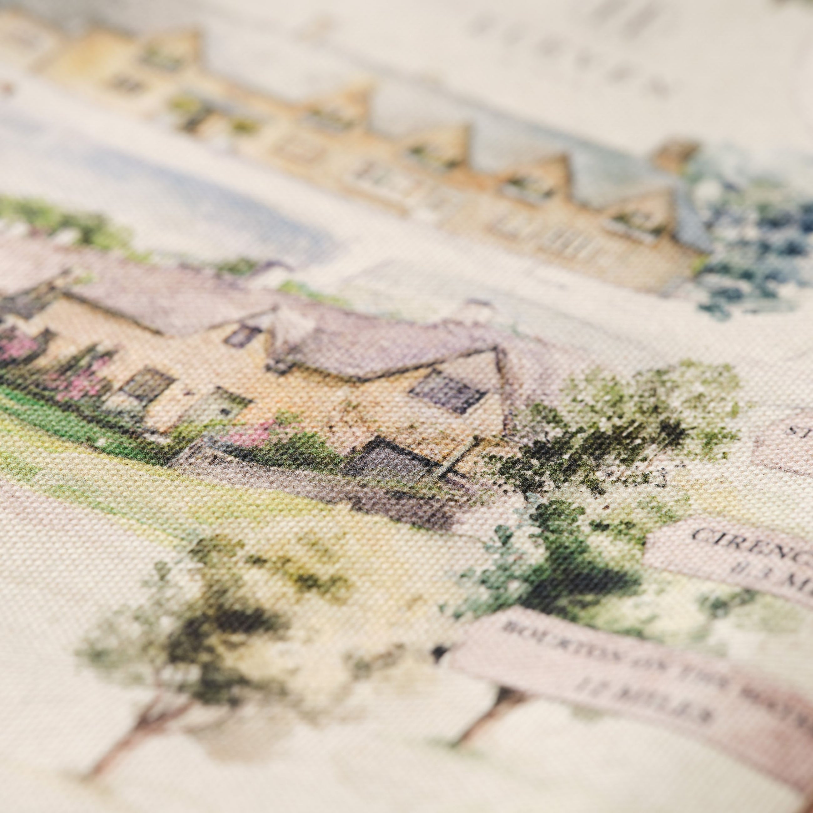 Close-up of a printed tea towel with Bibury Map design with houses and trees on cotton fabric.
