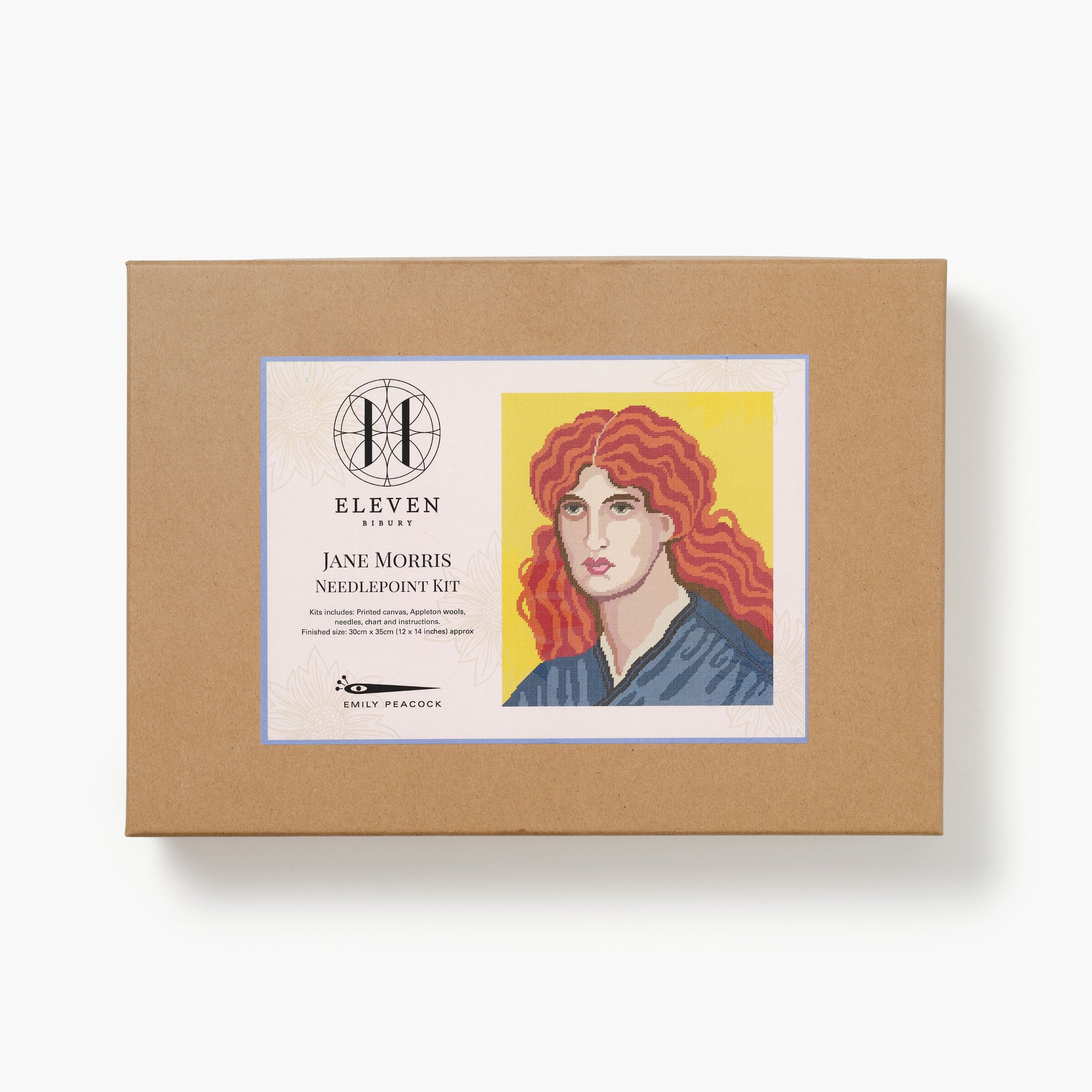 Brown box with a needlepoint kit label featuring an illustration of Jane Morris with red hair on a white background