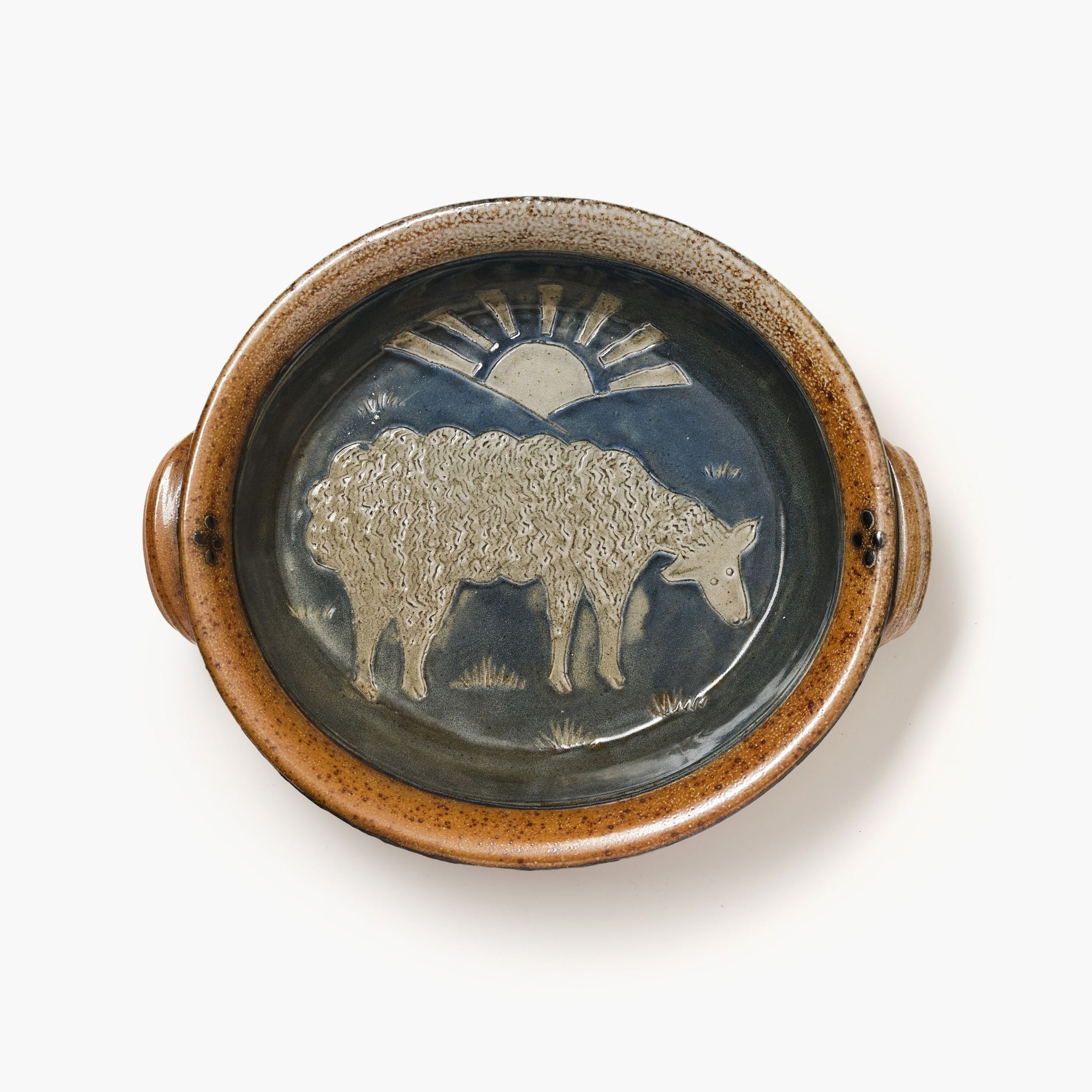 Ceramic plate with a sheep design and sun on a white background
