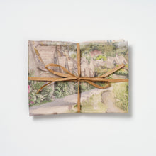 Arlington Row cotton tea towel folded and tied with raffia on a white background