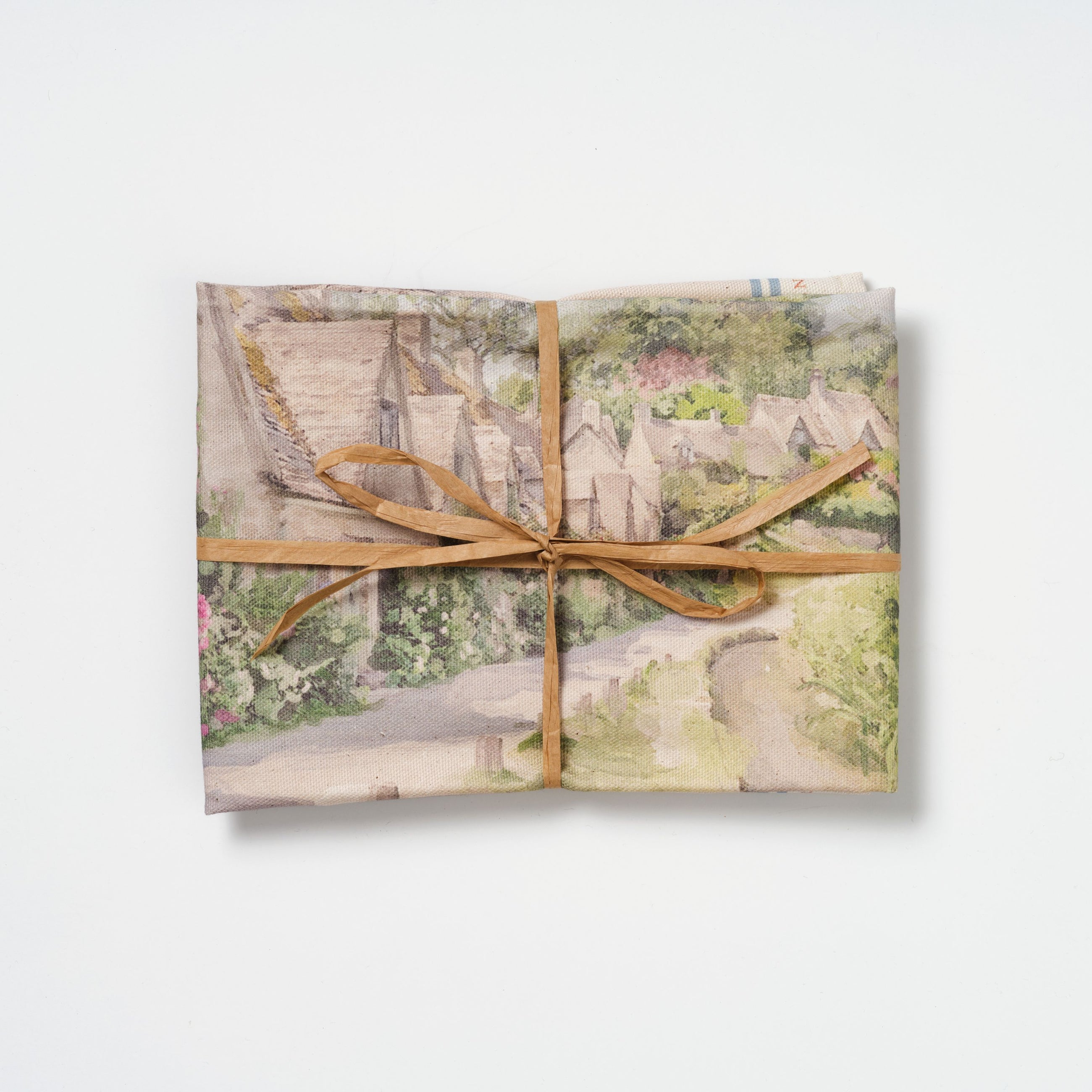 Arlington Row cotton tea towel folded and tied with raffia on a white background