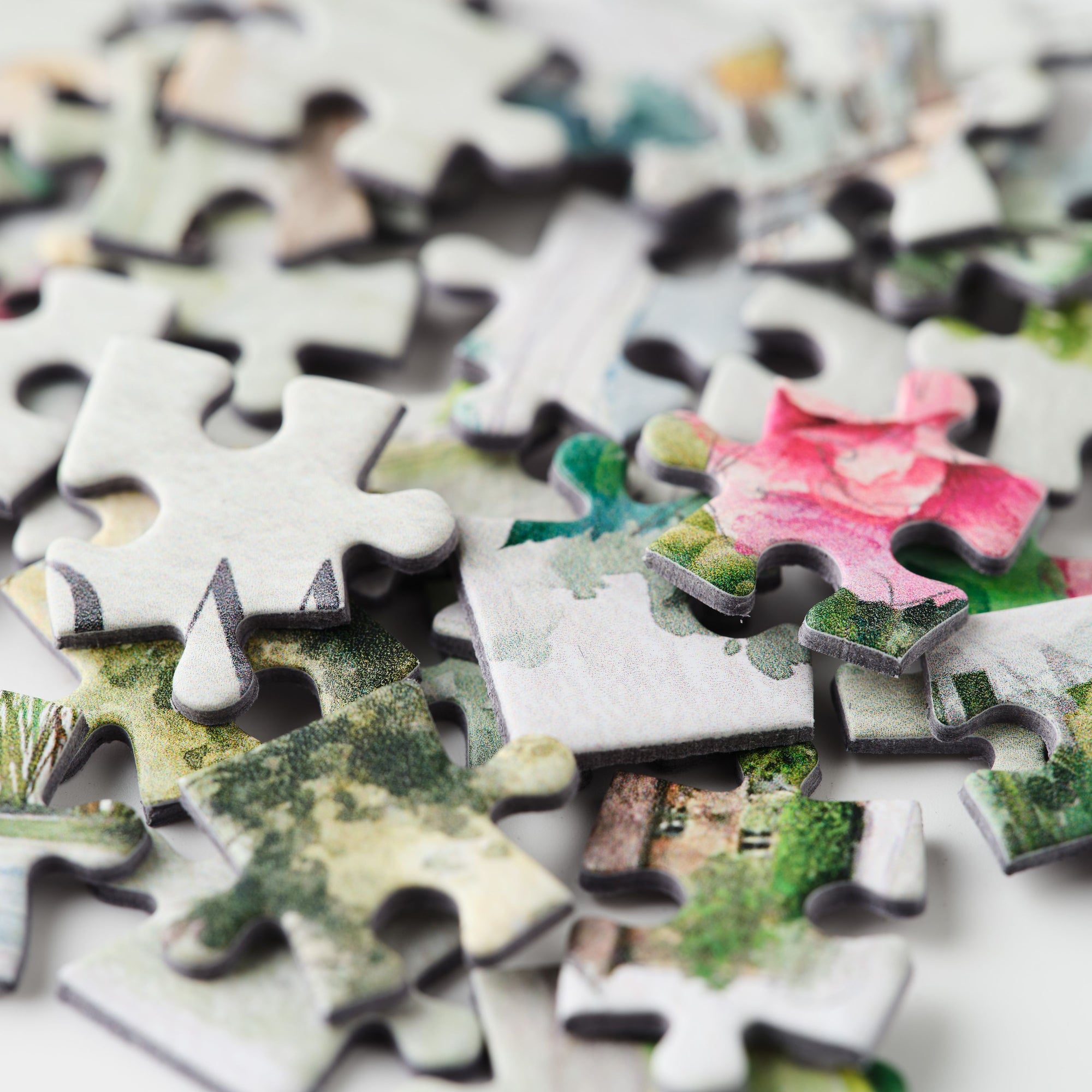 Close-up of puzzle pieces with various images on a white background