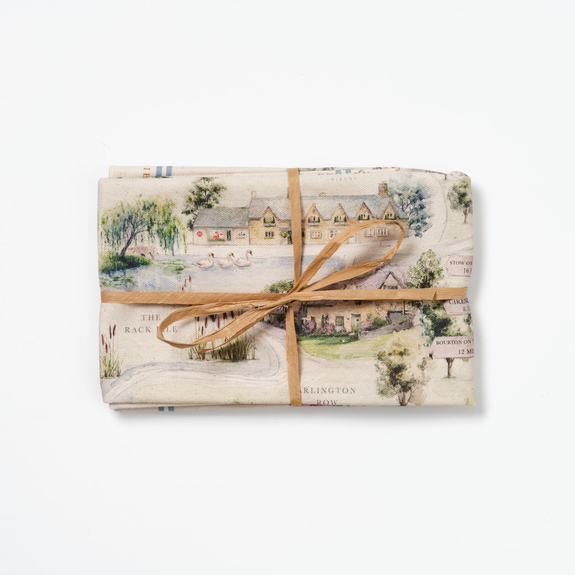 Folded Bibury Map tea towel tied with raffia on a white background.