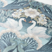 Close up of decorative Bibury Swan fabric with swans and floral patterns on a blue background