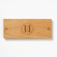 Oak charcuterie board with engraved Eleven Bibury logo on a white background