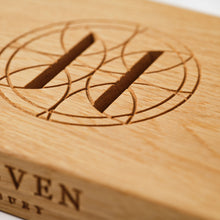 Close-up of Oak charcuterie board engraved with Eleven Bibury logo