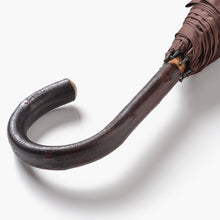 Close up of chestnut crook handle on umbrella