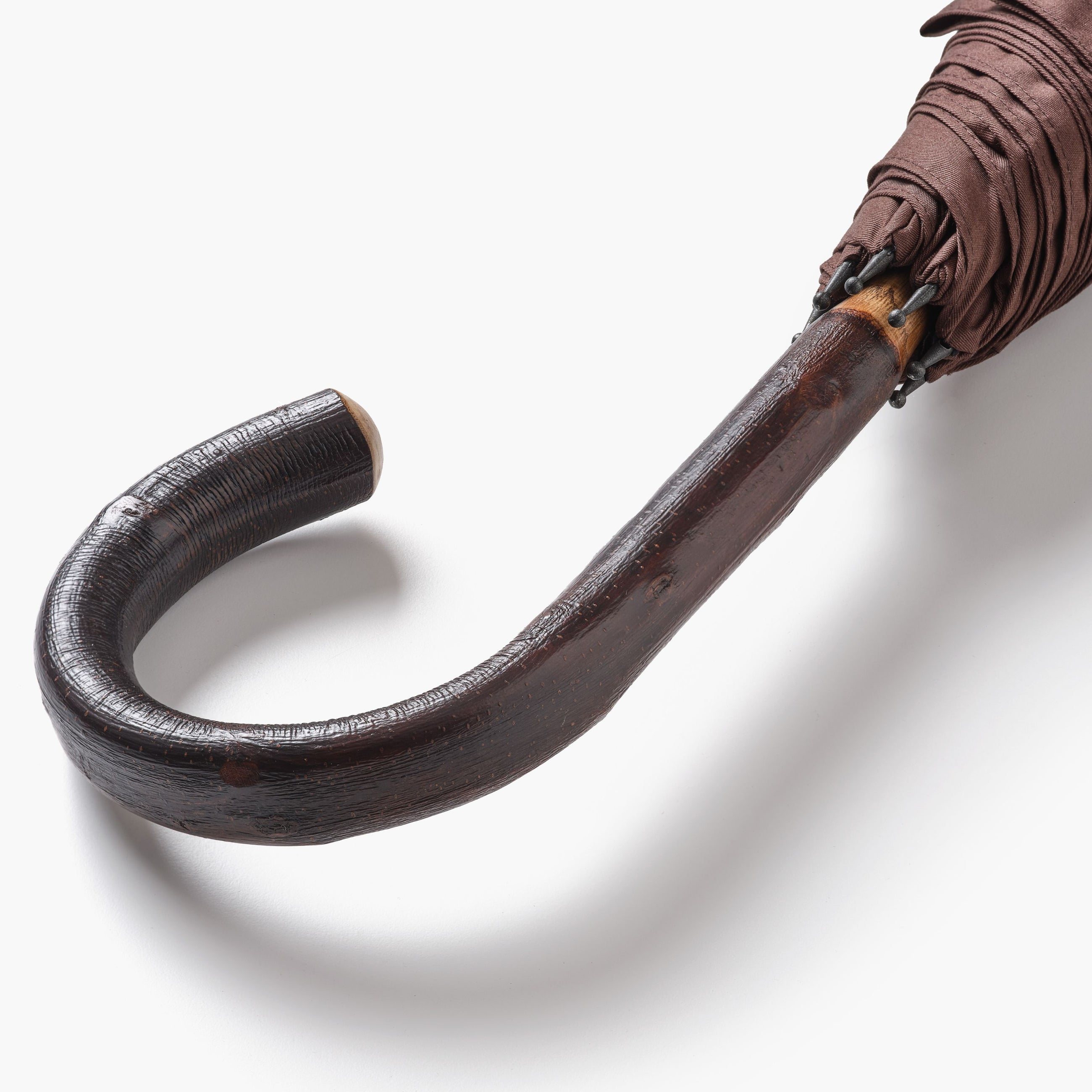 Close up of chestnut crook handle on umbrella