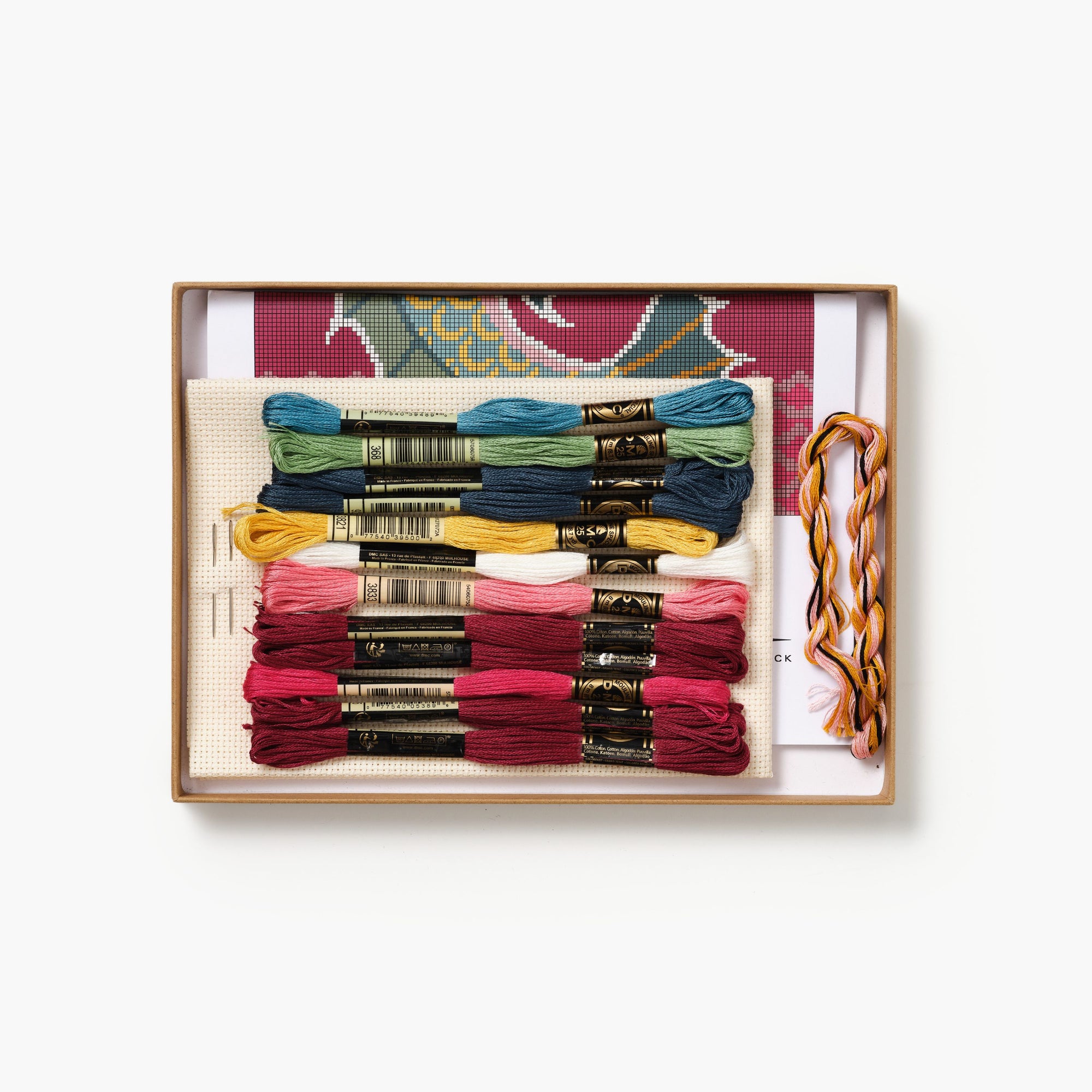 Embroidery thread set with colorful skeins in a wooden box on a white background