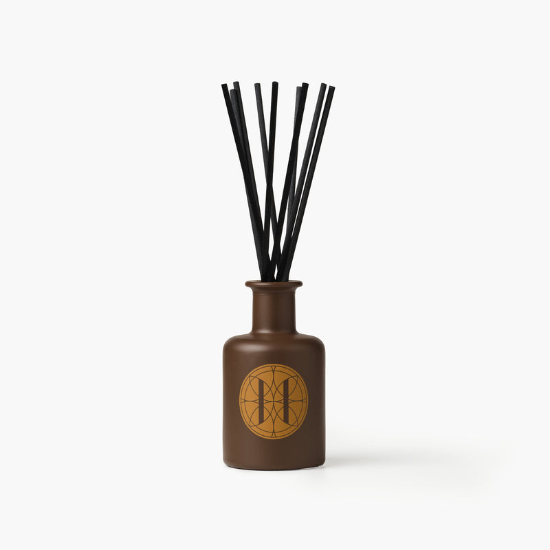 Eleven Bibury 'Gabriel's Muse' brown diffuser bottle with black sticks on a white background
