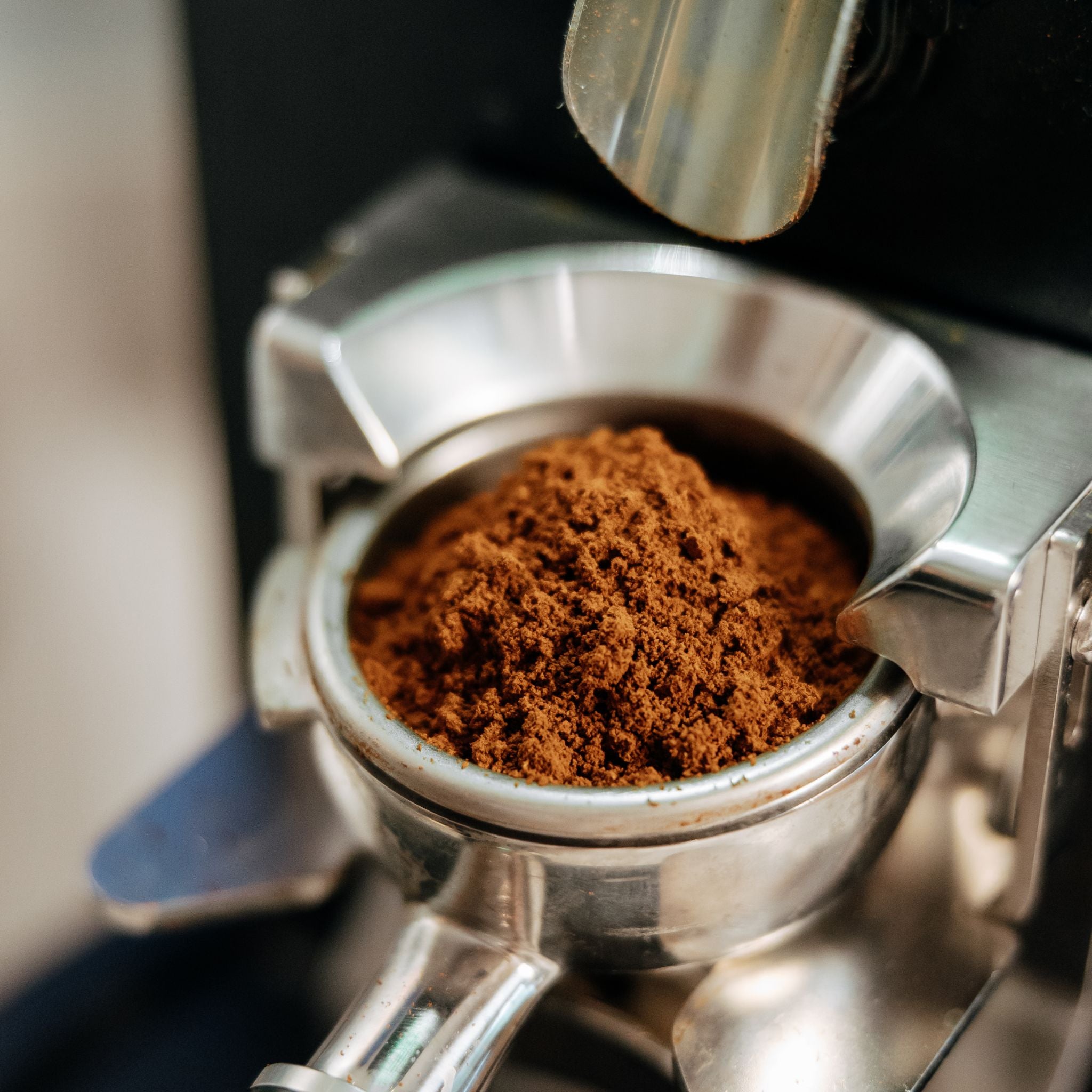 Close-up of a portafilter with ground coffee beans.