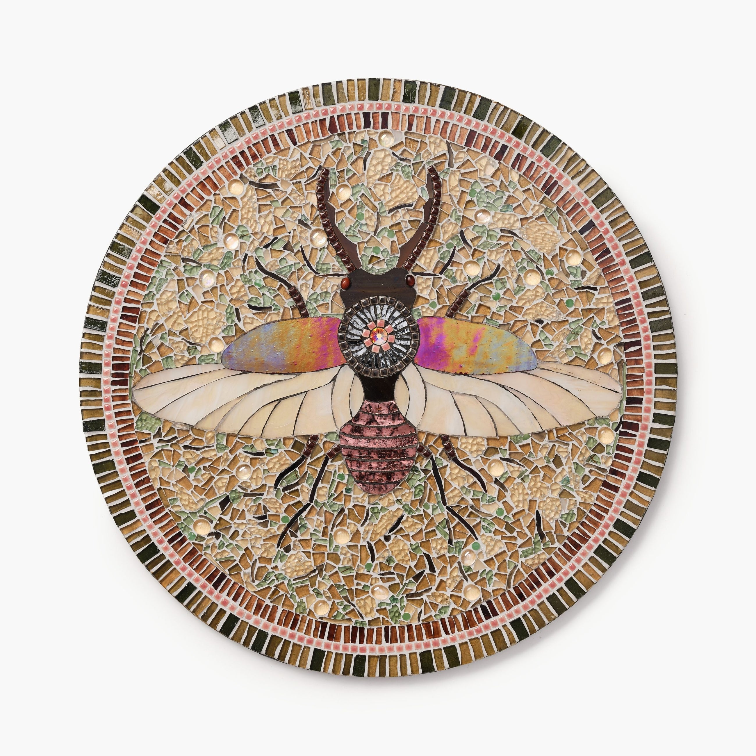 Mosaic artwork of a beetle with colorful wings on a circular plate.