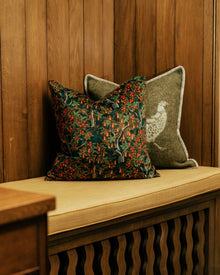 Decorative pillows on a wooden bench against a wooden window seat.