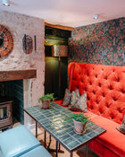 Room with red sofa, green tiled coffee table, and decorative elements.