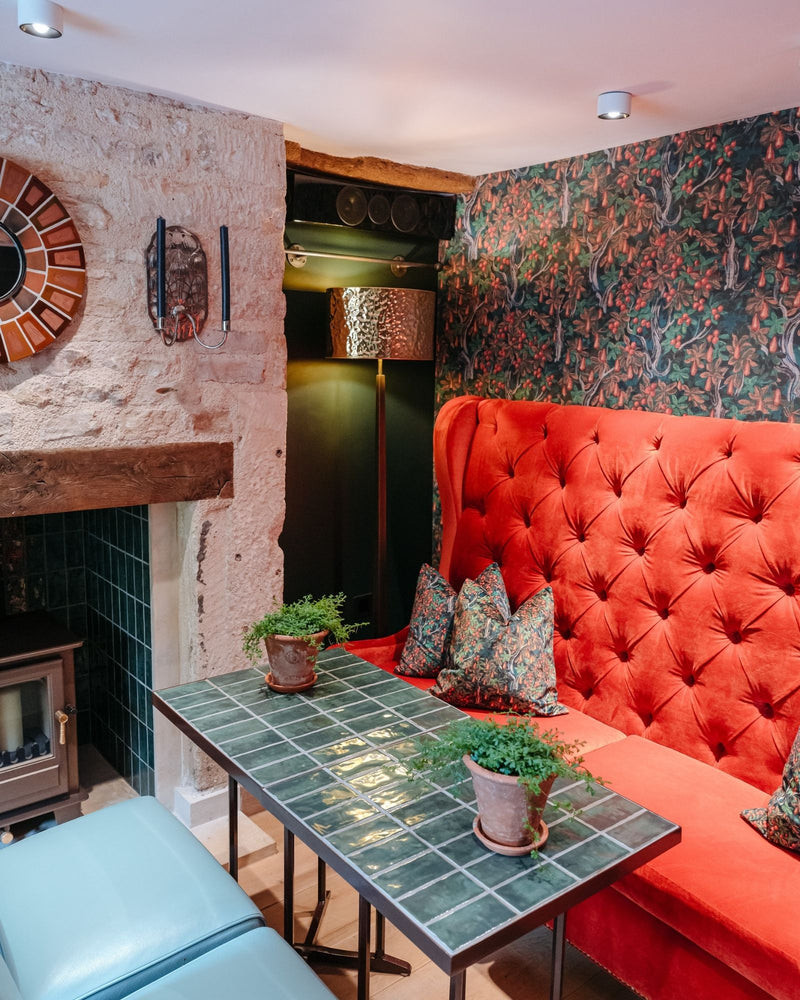 Room with red sofa, green tiled coffee table, and decorative elements.