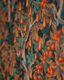 Close-up of a wallpaper with a detailed pattern of leaves and berries.