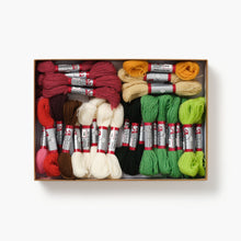 Box of colorful embroidery threads with thread spools and skeins on a white background
