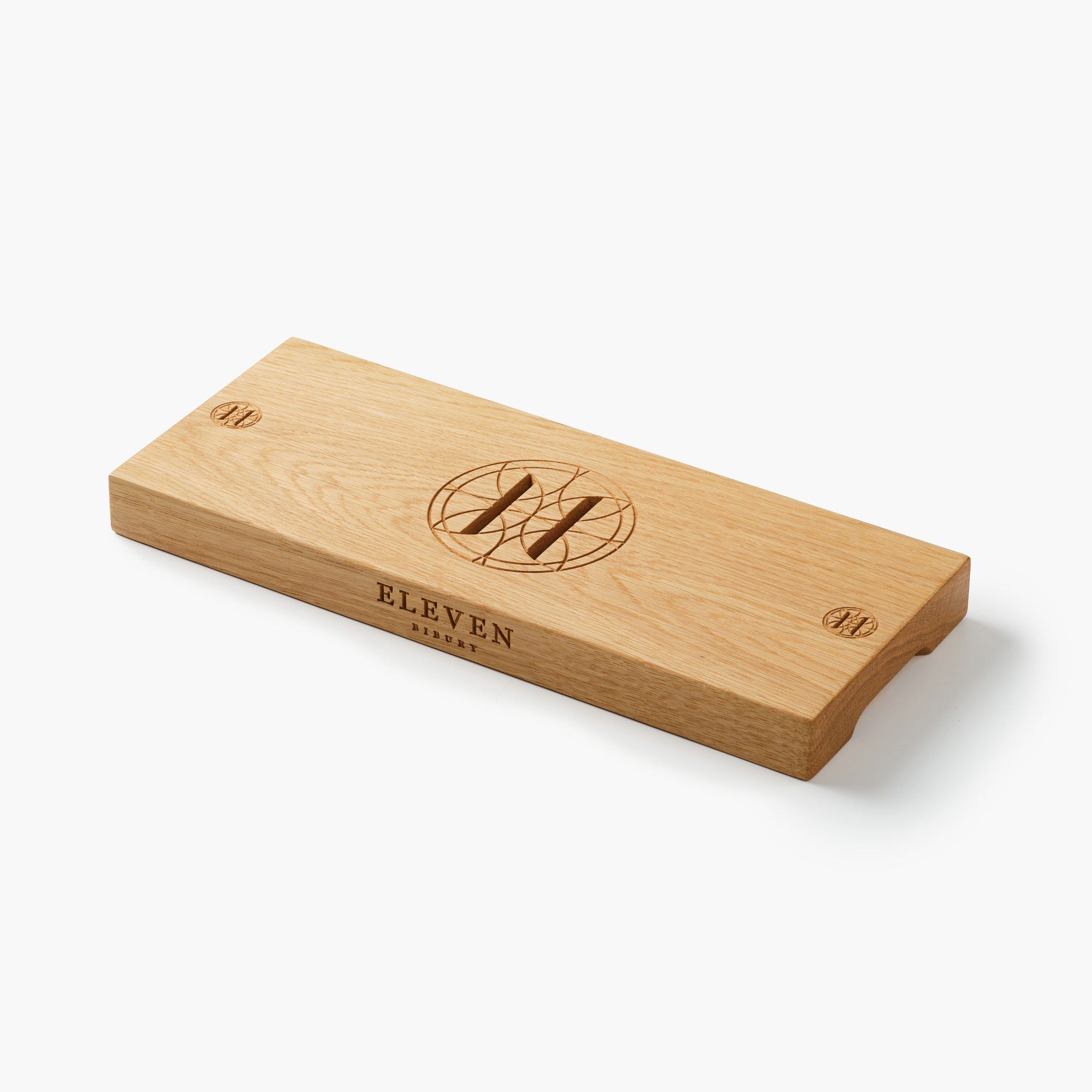 Wooden charcuterie board engraved with 'ELEVEN BIBURY' branding on a white background