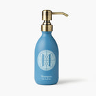 Eleven Bibury 'Rack Isle' blue shampoo bottle with gold pump on a white background