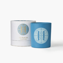 Eleven Bibury 'Rack Isle' blue candle and white cylindrical container with decorative logo on a white background