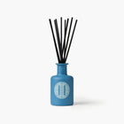 Eleven Bibury 'Rack Isle' blue diffuser bottle with black sticks on a white background