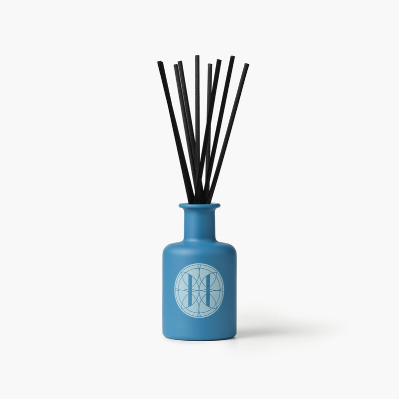 Eleven Bibury 'Rack Isle' blue diffuser bottle with black sticks on a white background