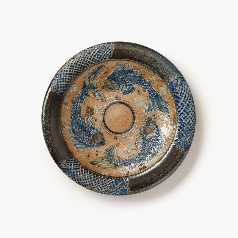 Decorative ceramic plate with fish design on a white background