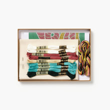 Embroidery thread set with colorful skeins and patterns in a box on a white background