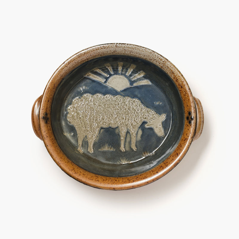 Ceramic plate with a sheep design and sun on a white background