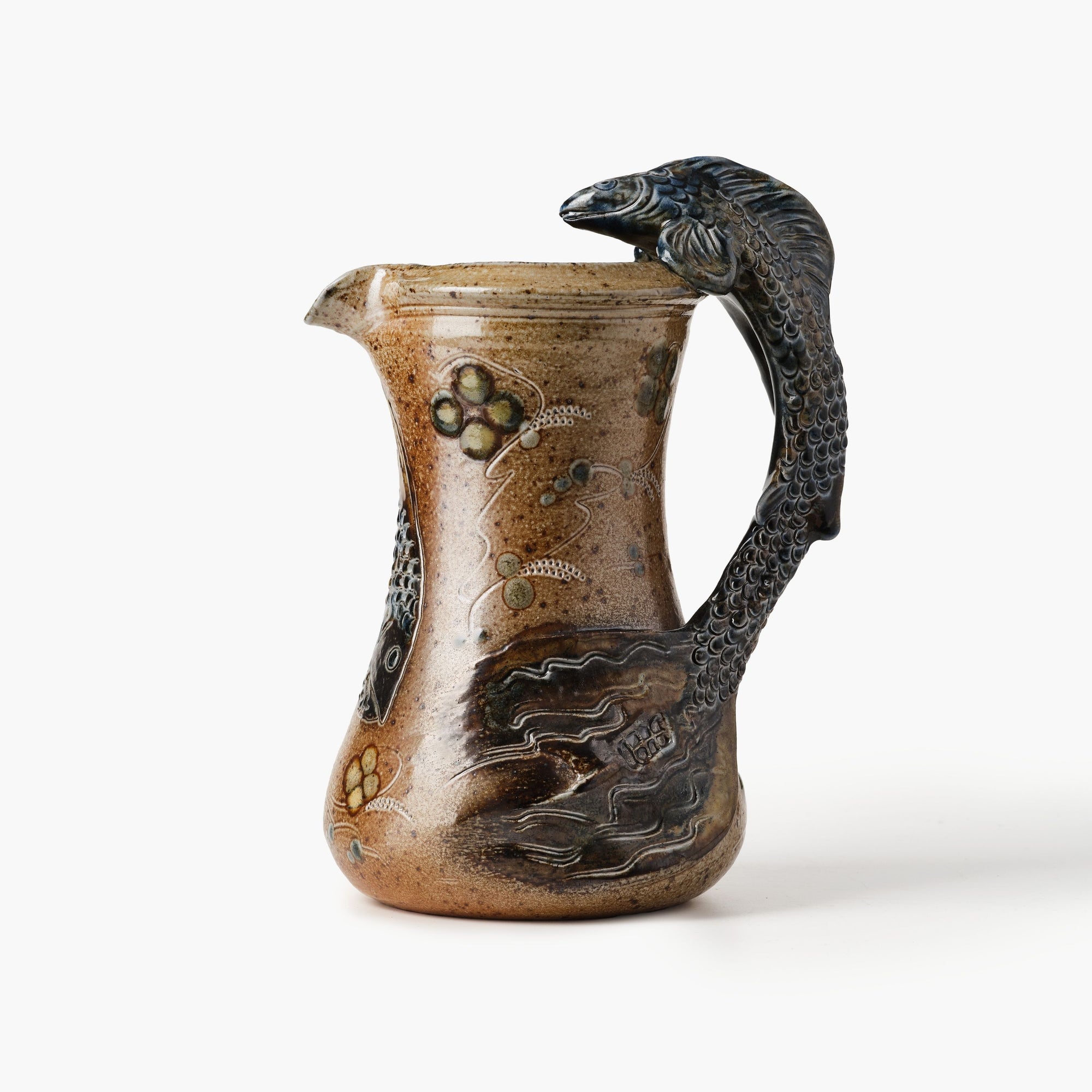 Ceramic pitcher with fish handle on a white background