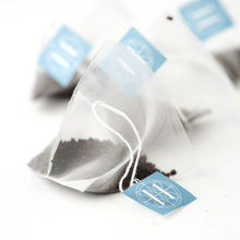 Eleven Bibury Tea bags with blue labels on a white background
