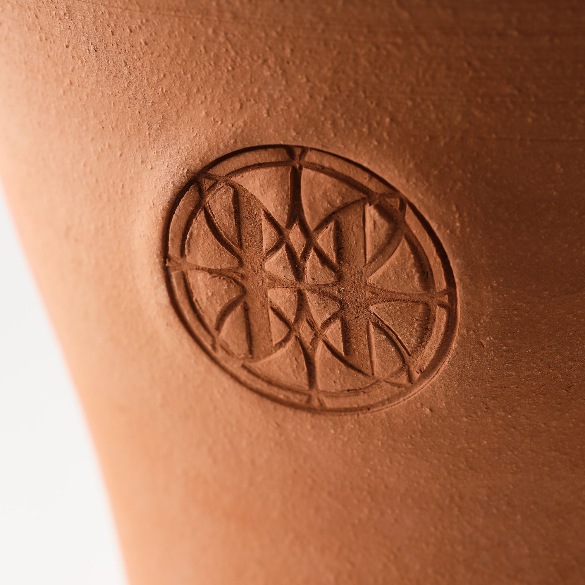 Close-up of Eleven Bibury logo on a terracotta pot