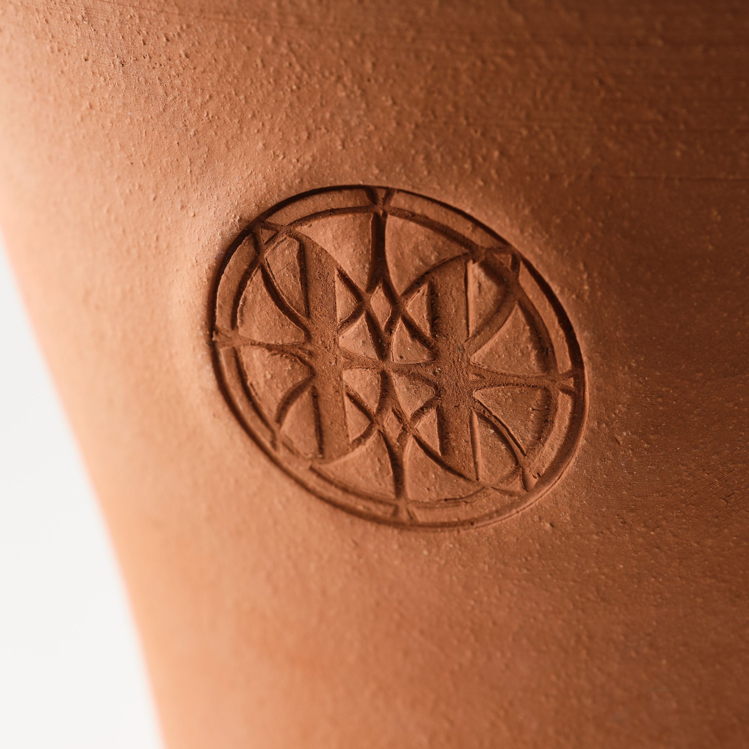 Close-up of Eleven Bibury logo on a terracotta pot