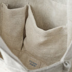 Close-up of the inside of a textured beige linen tote bag on a white background