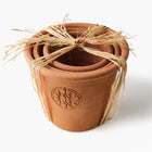 Set of three terracotta pots with Eleven Bibury logo tied with raffia on a white background